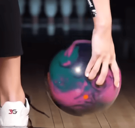 bowling ball with hand on it giving it less rotation and revs